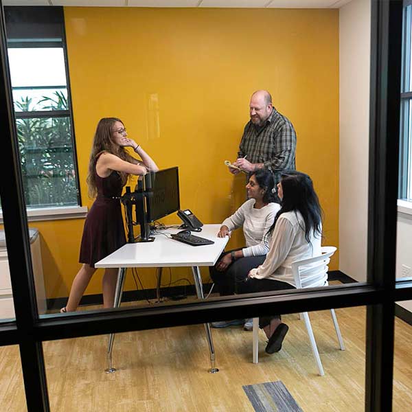 A group of LimoLink emoployees work collectively around a desk