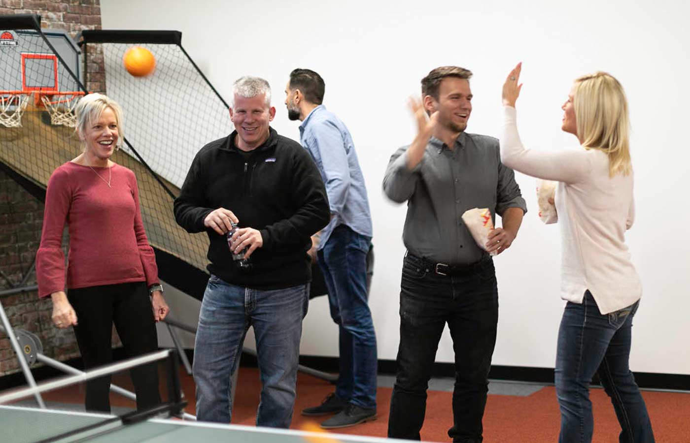 LimoLink team members lauch in the breakroom while playing ping pong