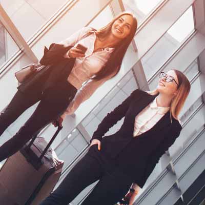 Two business women walk through an airport