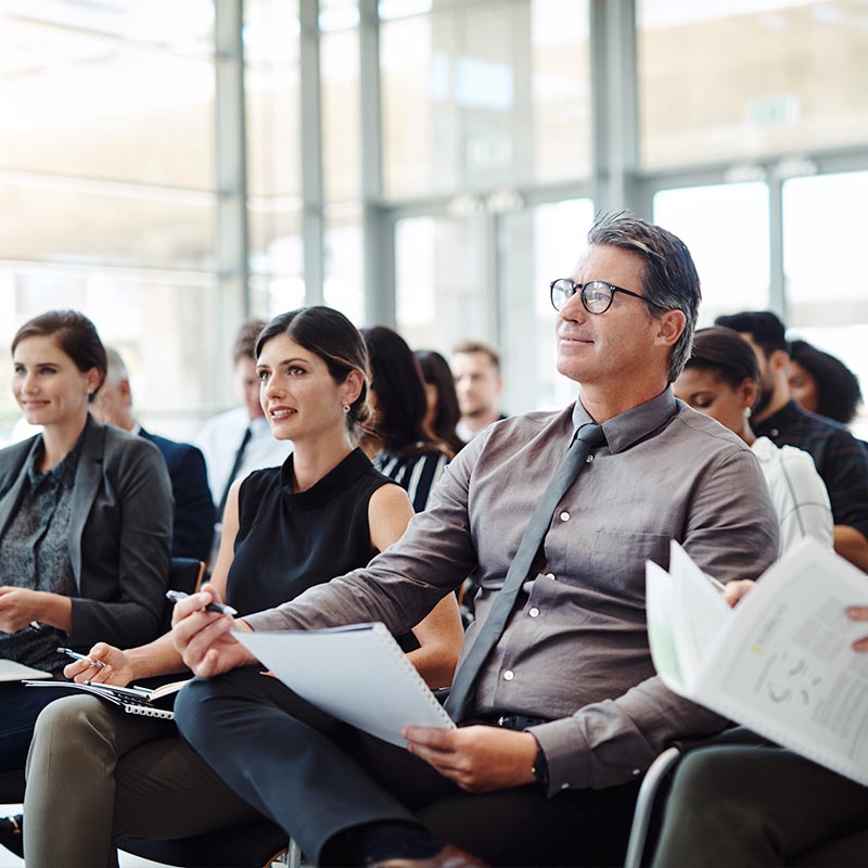 A group of alert middle aged buisiness people attend a meeting