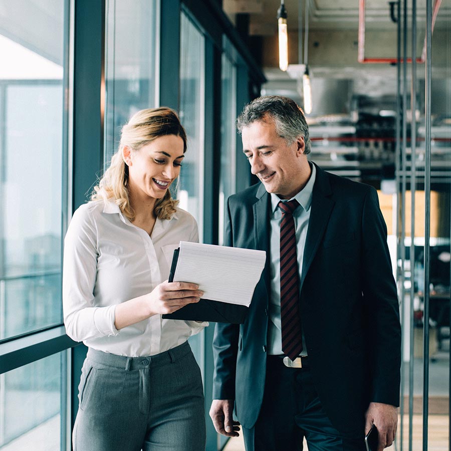 A personal assitant shows her boss information on a notepad